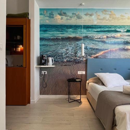 a bedroom with a painting of the ocean at Christina Beach Hotel in Chania