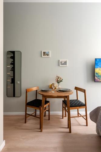 a dining room with a table and two chairs at Historical House Apartments in Rīga