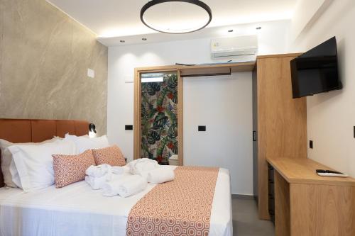 a bedroom with a bed with towels on it at Elite Luxury Suites Bali Rethymno in Balíon