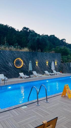 a swimming pool with chairs and umbrellas in a resort at Karaöz Sapphire Bungalows in Kumluca