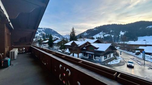 a view from a balcony of a town with snow at Super Luxurious Duplex Penthouse in Gstaad Center in Gstaad