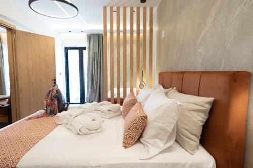 a bedroom with a bed with white sheets and pillows at Elite Luxury Suites Bali Rethymno in Balíon