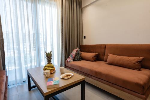 a living room with a brown couch and a table at Elite Luxury Suites Bali Rethymno in Balíon