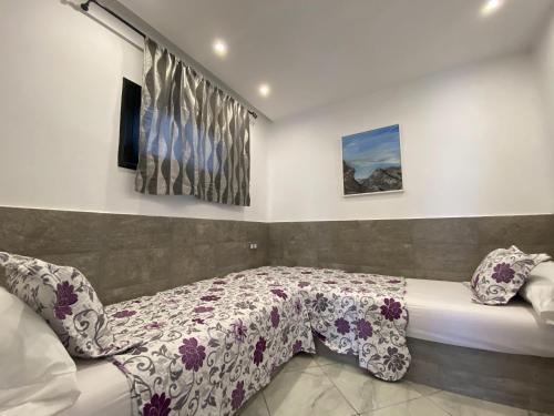 a bedroom with a bed with a floral bedspread at Complexe Al AMINE plage -rifiyine in Dar Merah Deriba