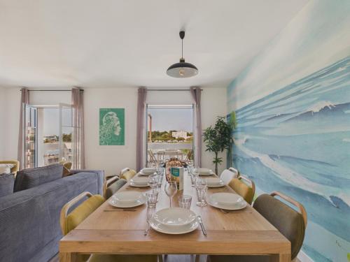 une salle à manger avec une table et des chaises en bois dans l'établissement Vue rivière - Bel appartement avec balcon pour 8, à Saint-Gilles-Croix-de-Vie