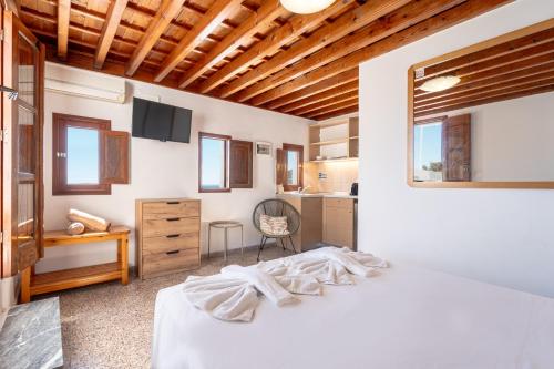 a bedroom with a white bed and a desk at Arte Lindos Suites in Líndos