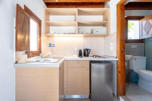 a small kitchen with a sink and a toilet at Arte Lindos Suites in Líndos