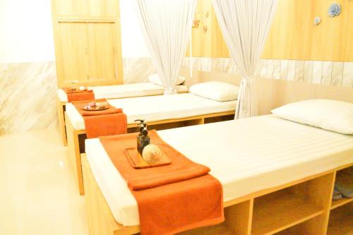 a room with three beds and a mirror at Neenlawat Riverside in Surat Thani