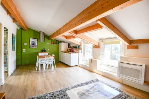 - un salon avec des murs verts et une table dans l'établissement Bel appart avec terrasse et vue sur Notre-Dame, à Marseille