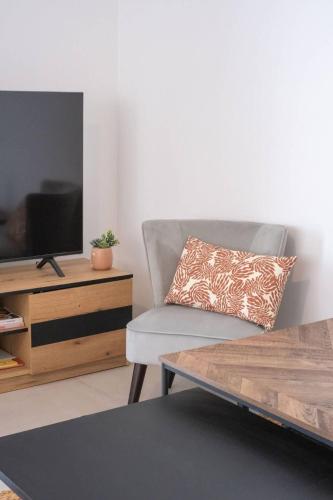 un salon avec un canapé et une télévision dans l'établissement Valras-Loc Archipel Panarea Horizon Bleu, à Valras-Plage