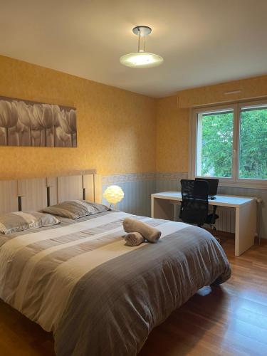une chambre avec un grand lit et un bureau dans l'établissement Maison Changé, à Changé