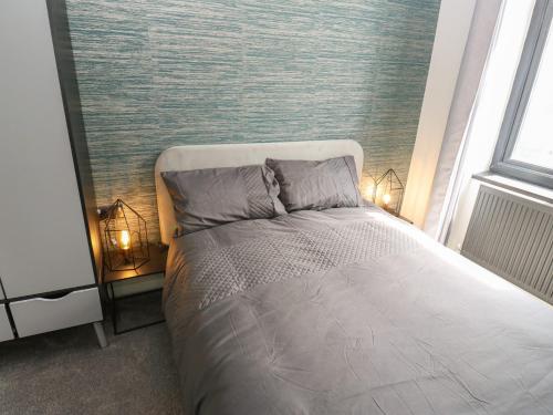 a bedroom with a bed with two lamps on it at Myrtle Loft in Keighley