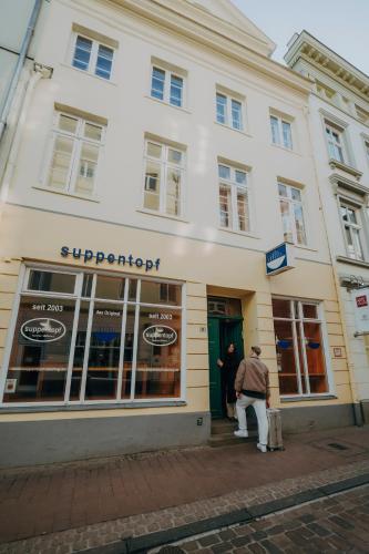 a man is standing outside of a store at Apartments Fleischhauerstraße in Lübeck