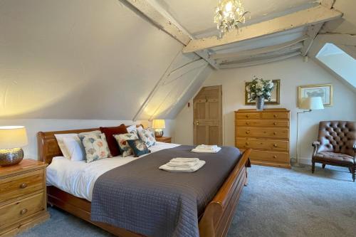 a bedroom with a large bed and a chair at The Coach House by Bloom Stays in Harrietsham
