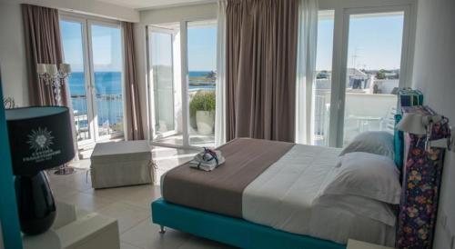 a bedroom with a bed with a view of the ocean at Hotel Cicò in Torre Santa Sabina