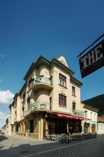 a large building with tables and chairs in front of it at 1910 Boutique - Central, Scenic, Self Check-In in Braşov