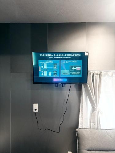 a flat screen tv hanging on a wall at Ikebukuro正和庵 in Tokyo