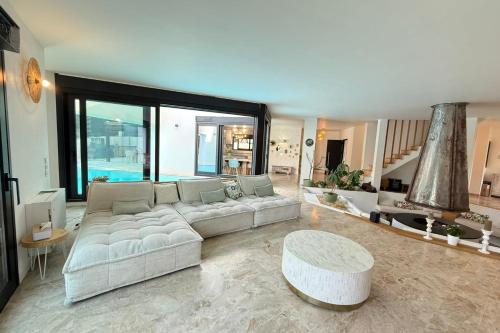 un salon avec un canapé blanc et une table dans l'établissement Magnificent modern villa - swimming pool - terrace - garden, à Biot