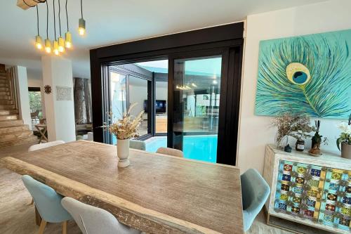 une salle à manger avec une table en bois et des chaises bleues dans l'établissement Magnificent modern villa - swimming pool - terrace - garden, à Biot