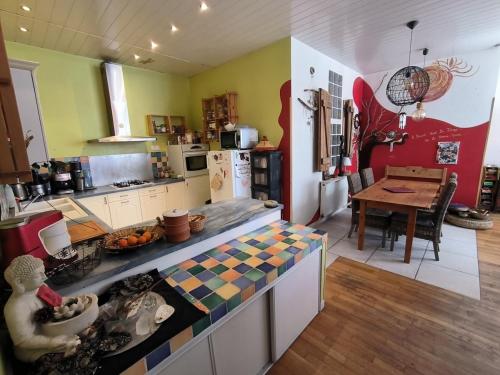 une cuisine avec un comptoir et une table à l'intérieur dans l'établissement Charmant apartement au coeur de Briançon, à Briançon