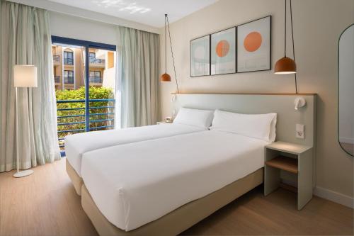 a bedroom with a large bed and a window at Sol Sancti Petri Aparthotel in Chiclana de la Frontera
