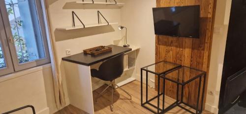 Cette chambre comprend un bureau avec une chaise et une télévision. dans l'établissement Studio meublé Ecusson - Comédie et gare à pied !, à Montpellier