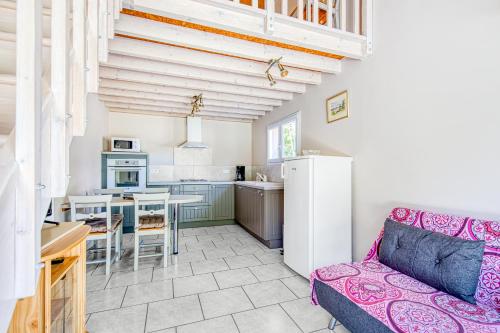 un salon avec un canapé et une cuisine dans l'établissement Entre Vignobles Et Océan, à Queyrac