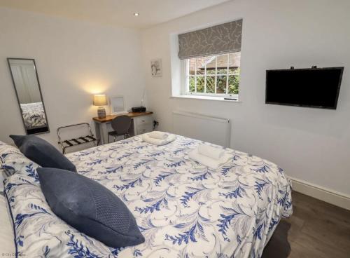 a bedroom with a bed and a couch and a television at 4B City Cottages in Chester