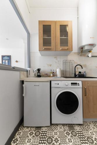 a kitchen with a washing machine and a counter at Le Four Plaisance - Appartement cosy Parcs Opéra in Vichy