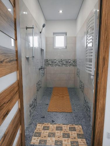 a bathroom with a shower with a glass door at Sodyba Miško pakrašty in Gailiūnai