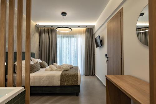 a bedroom with a bed and a large window at Elite Luxury Suites Bali Rethymno in Balíon