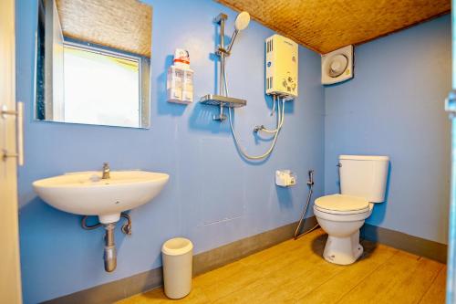 a blue bathroom with a sink and a toilet at ภูสกาย โฮมสเตย์ in Mon Jam