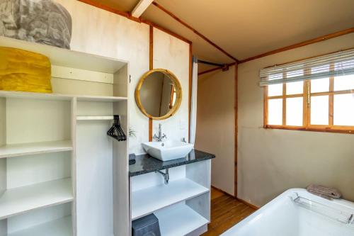 a bathroom with a sink and a tub and a mirror at Jabula Bush Camp in Klipdrift