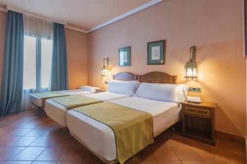 une chambre d'hôtel avec deux lits et une fenêtre dans l'établissement Moon Dreams El Cortijo, à Matalascañas