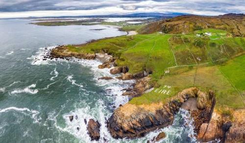 an aerial view of a golf course on the ocean at Cosy home by the sea in Dungloe