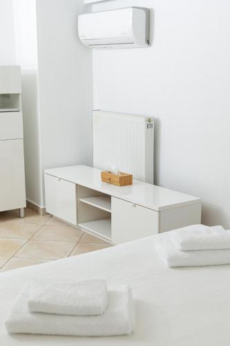 a white bedroom with a white desk with two white towels at Seaside Grey Pearl Villa in Piraeus