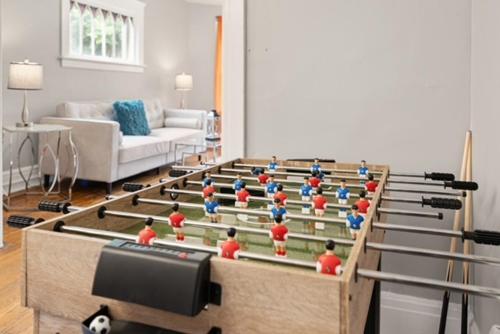 a living room with a table with people on it at Modern 6BR Near Syracuse U, Destiny & Zoo Sleeps 18 in Syracuse