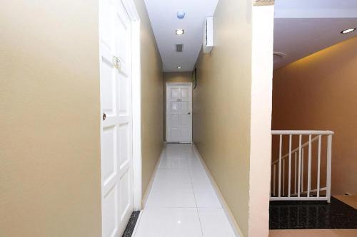 a hallway with a white door and a white tile floor at Heaven Mountain Hill 2 Cameron Highlands in Cameron Highlands