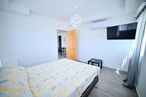 a bedroom with a bed and a flat screen tv at La Yarolina in Punta Cana