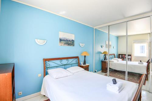 - une chambre bleue avec un lit et un miroir dans l'établissement Appart atypique avec 1 ch avec terrasse à Bompard, à Marseille