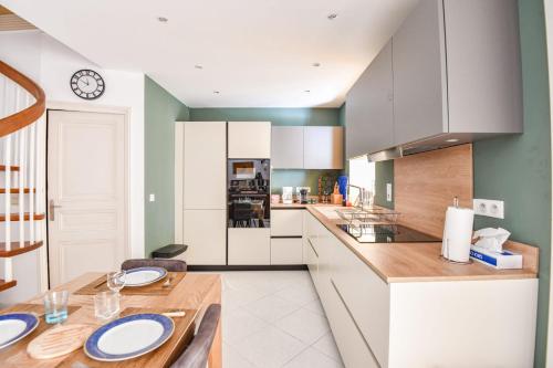 une cuisine avec une table et une horloge au mur dans l'établissement Appart atypique avec 1 ch avec terrasse à Bompard, à Marseille