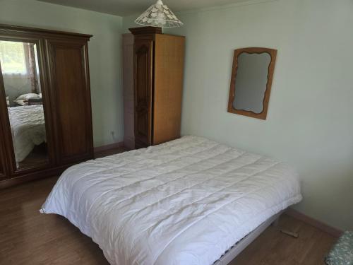 une chambre avec un lit blanc et un miroir dans l'établissement Cher bene, à Thérouldeville