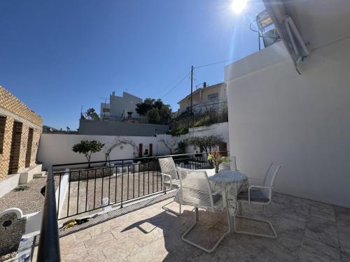a patio with a table and chairs on a balcony at The White House - Aianteio in Aiándion