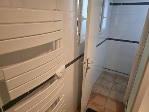 La salle de bains est pourvue d'armoires blanches et d'une douche. dans l'établissement Cher bene, à Thérouldeville