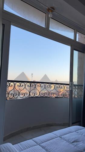 a bedroom with a window with a bed and a view at Luxury Panorama pyramids & jacuzzi in Cairo