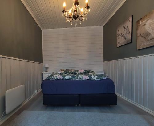 a bedroom with a bed and a chandelier at Charming central apartment in Narvik