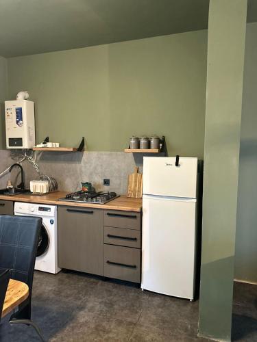 a kitchen with a white refrigerator and a stove at Guest Hous in Urekis Sadguri