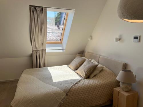 a small bedroom with a bed with a window at Nida & Sunrise *Self Check-In* in Nida