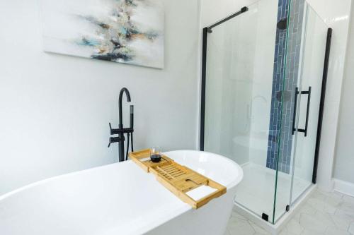 a bathroom with a white tub and a glass shower at Jennifer's Spa-Like Modern & Chic Broadway Retreat in Providence