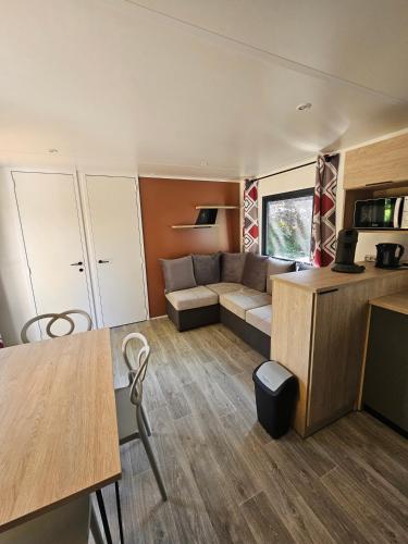 a living room with a couch and a table at Camping de Charlieu in Charlieu
